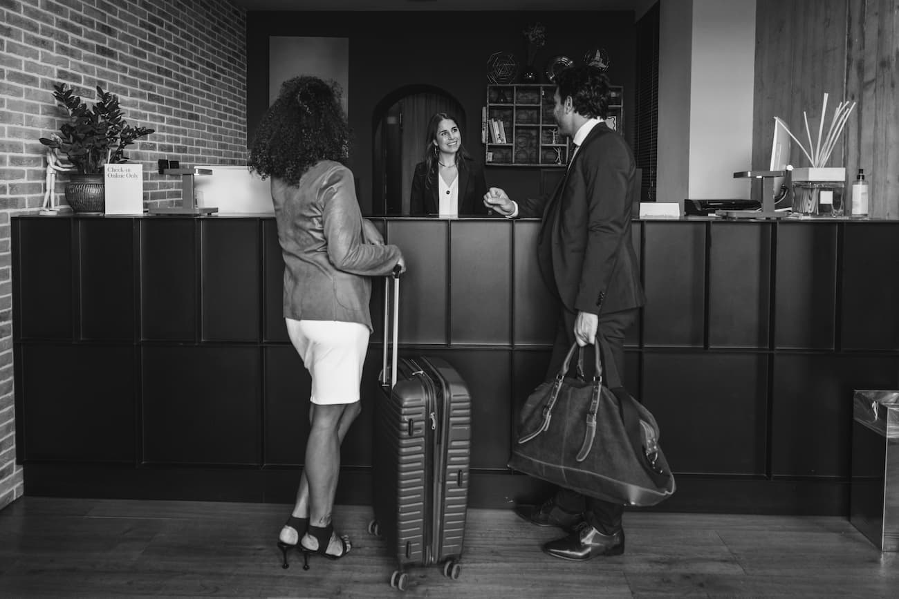 a woman behind a desk receiving twp people
