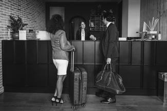 a woman behind a desk receiving twp people